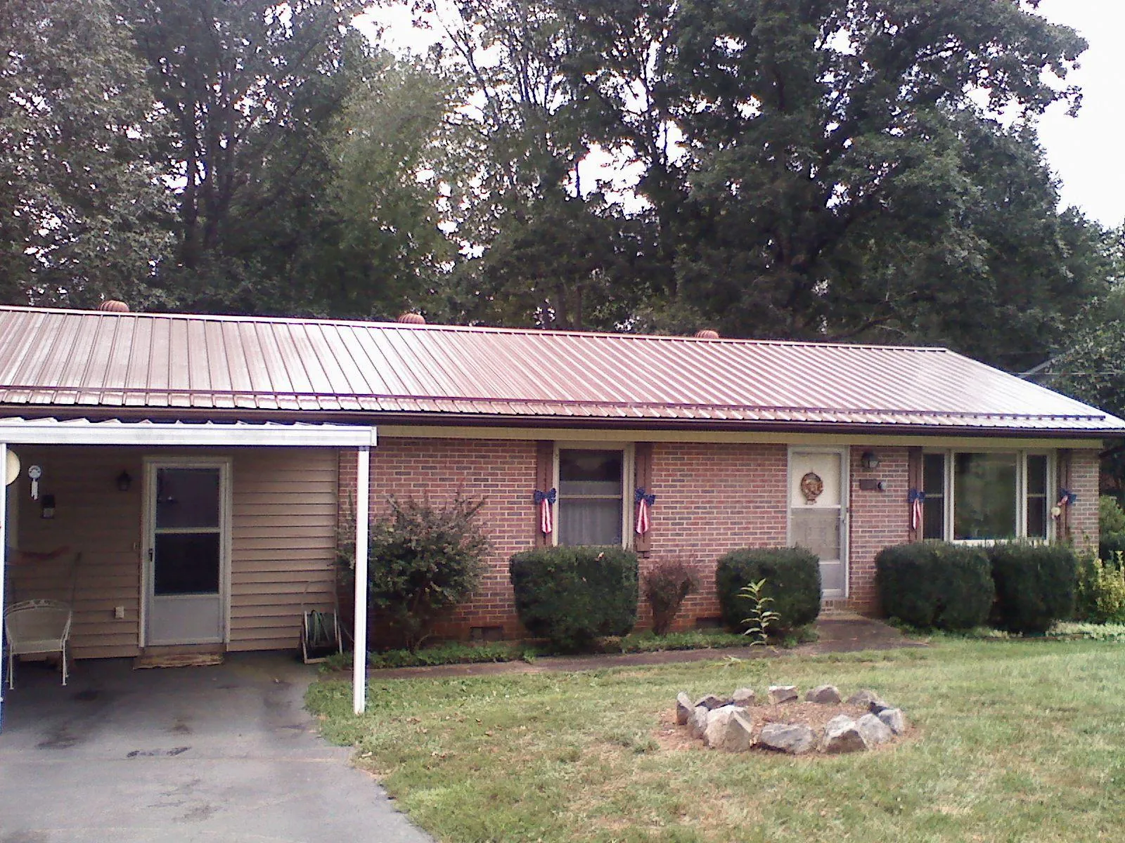 Bronze metal roof and carport on a brick ranch home — Roof Repair work by our crew in Newtown